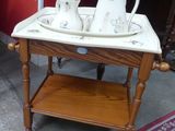 une petite table sur laquelle se trouve un plateau avec des tasses à thé et à café