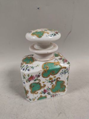 un petit vase blanc et vert avec un couvercle vert