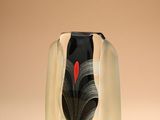 un vase noir et blanc contenant un cœur rouge