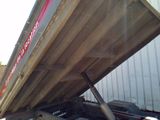 a dump truck that is sitting in the back of it ' s trailer
