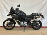 the black motorcycle is parked in front of a white backdrop