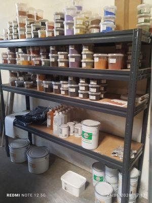 a shelf full of paint and other paints in a room