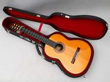 une guitare dans un étui, posée sur une surface blanche