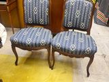 une paire de fauteuils rembourrés bleus dans une pièce avec un tapis jaune