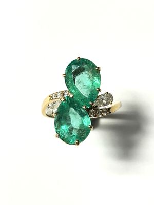 an emerald and diamond ring on a white background
