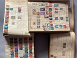 trois livres ouverts, sur lesquels sont apposés des timbres, posés sur une surface bleue