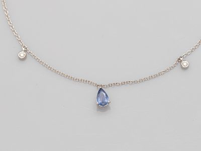 a blue sapphire and diamond necklace on a silver chain