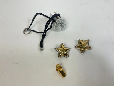 a pair of gold star charms and a black cord
