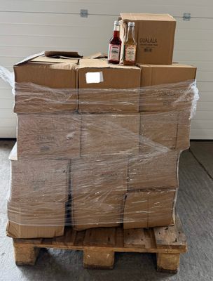 une grande pile de cartons posée sur une palette dans un garage