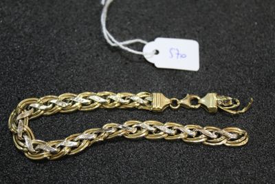 a close up of a gold chain bracelet with a tag on it
