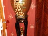 un vase posé sur un socle dans un coin de la pièce