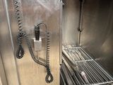 a phone that is hooked to the side of a metal cabinet