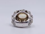 a close up of a silver ring with a white stone in the center