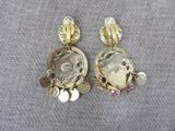 a close up of a pair of earrings on a cloth
