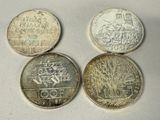 four different types of coins sitting on top of a white surface