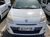 La voiture blanche est garée sur le parking, à côté de la camionnette blanche.