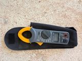 a close up of a clamp meter sitting on top of a black bag