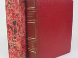 two red books sitting next to each other on a white surface
