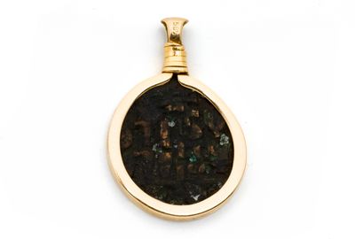 une image représentant un pendentif en or avec une pièce romaine au centre