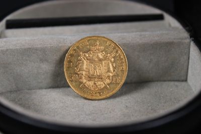 une pièce d'or posée dans une boîte sur une table