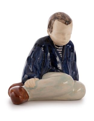 a figurine of a man sitting on the ground
