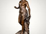 a bronze statue of a woman holding a basket of flowers