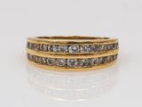 a yellow gold ring with three rows of diamonds
