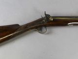 a rifle with a wooden barrel and brass fittings on a white background