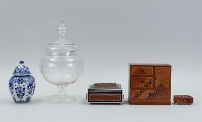 un bocal en verre, une boîte et une boîte d'allumettes posés sur une surface blanche