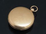 a gold colored pocket watch on a black surface