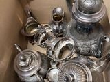 a box full of silver teapots and other silverware