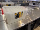 un récipient en plastique posé sur un comptoir en métal