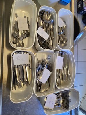 beaucoup de couverts dans les plateaux posés sur le plan de travail de la cuisine