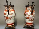 pair of asian vases with handles on stands on a gray background