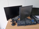 deux écrans et un clavier posés sur un bureau, à côté d'un ordinateur portable