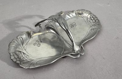 un plateau en argent orné d'une fleur, posé sur une table