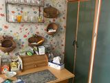 a desk with a chair in front of a wallpapered wall