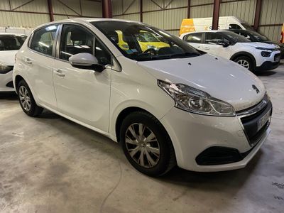 La petite voiture blanche est garée dans un garage avec d'autres voitures.