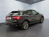 the rear end of a black audi qx parked in a showroom
