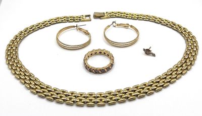 a close up of a necklace, bracelet and ring on a white surface