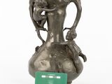 a silver vase that has a card on it