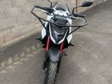 une moto noire et blanche garée devant un mur de briques