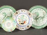 cinq assiettes aux motifs variés sont alignées sur une surface noire