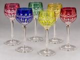 several different colored wine glasses are lined up in a row