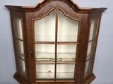 a wooden display case with glass doors and a wooden base