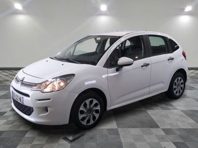 the white citrole is parked on a checkered tile floor
