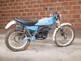 a blue motorcycle parked in front of a brick wall