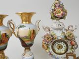 three vases and a clock sitting on a table