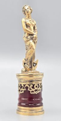 une statue en or représentant une femme tenant un enfant dans ses bras, posée sur un socle