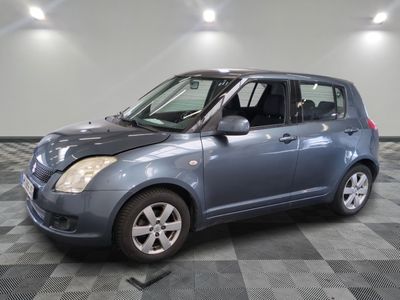 une petite voiture bleue garée sur un sol en damier